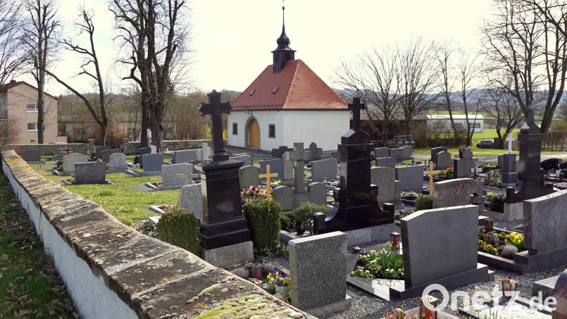 In den nächsten Wochen wird die notarielle Urkunde für den Besitzübergang des Kulmainer Friedhofs an die Gemeinde unterzeichnet. Eine lange Mauer grenzt den Gottesacker von der Kemnather Straße ab. Bild: bkr