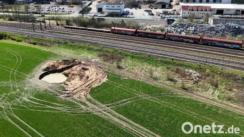Zwei Tage nach dem Fund zweier Bomben aus dem Zweiten Weltkrieg ist das Loch im Acker am Standrand von Amberg noch gut sichtbar. Von der Evakuierung betroffen war auch die Luitpoldhütte (im Hintergrund). Bild: hbe