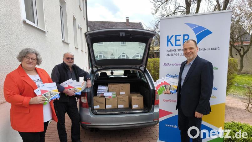 KEB-Vorsitzender Sebastian Sonntag (Mitte), der Leiter der KEB-Geschäftsstelle Christian Irlbacher (rechts) und die Sekretärin Daniela Rumpler (links) sind dabei, die Programmhefte unter die Leute zu bringen. Bild: KEB Amberg-Sulzbach/exb