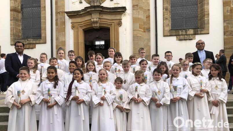 33 Kinder aus Vilseck, Schlicht und Sorghof empfangen in Vilseck und Schlicht die Erstkommunion. Zusammen mit Stadtpfarrer Pater Robin (links) und Pfarrvikar Pater Jimmy Joseph (rechts) stellen sie sich nach der Dankandacht vor der Kirche in Vilseck zum Erinnerungsfoto auf. Bild: ct