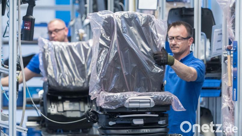 Mitarbeiter arbeiten in der Produktion beim Autozulieferer Grammer an Fahrersitzen. Bild: Armin Weigel/dpa