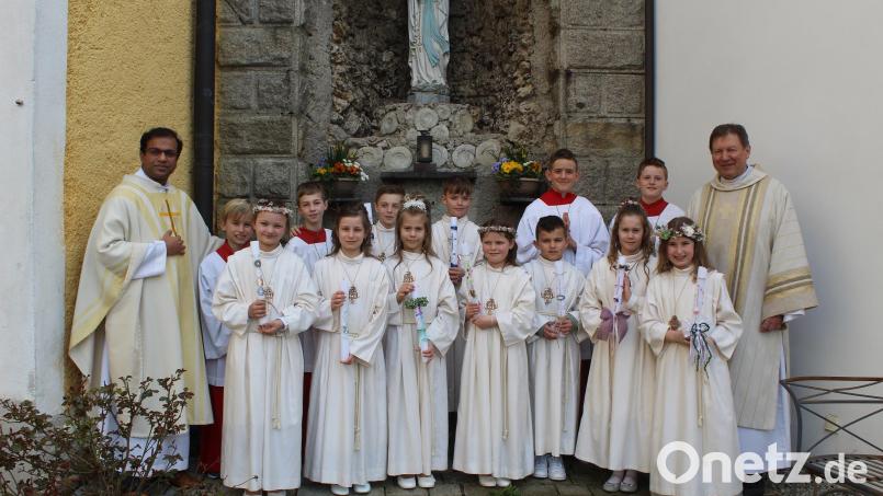 Pfarrer Pater Anish George (links) und Diakon Rudolf Hoffmann (rechts) mit den Kommunionkindern Bild: soj/exb