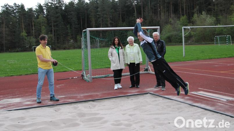 DJK-Abteilungsleiter Sportabzeichen, Erwin Götz (im Sprung) macht vor, wie es geht. Im Hintergrund messen die Prüfer Michael Birner und Winfried Kraus (links und rechts) den Sprung. Gründungsmitglied Annemarie Nachtmann (Dritte von links) und Prüferin Silvia Hauer-Kassner bewerten den Sprung. Bild: prh