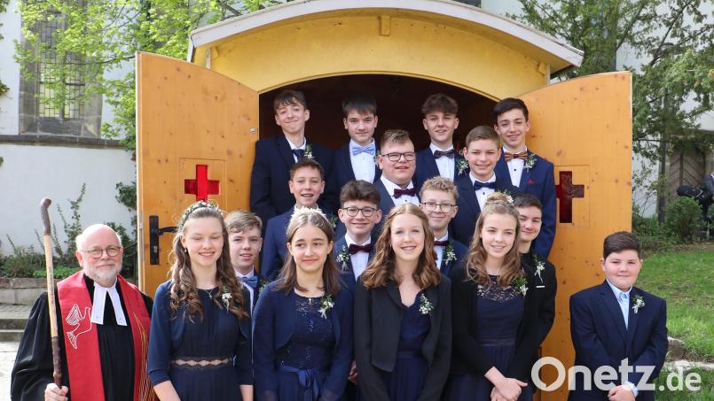 Vier Mädchen und zwölf Jungen nach dem Konfirmationsgottesdienst mit Pfarrer Matthias Ahnert vor der Schäferwagenkirche. Bild: gru