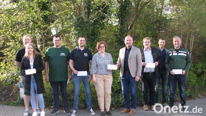 Über den Geldsegen des Kartellsvorsitzenden Richard Kammerer freute sich Anja Kraus (Mitte) von der Volksschule Mantel. Auch die teilnehmenden Vereine am Gaudiwurm erhielten einen guten Teil vom Reinerlös. Bild: knh