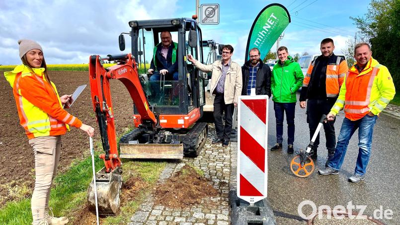 Bürgermeister Uwe König hebt unter fachmännischer Beobachtung mit dem Bagger die erste Vertiefung für das Glasfaserkabel in Thansüß aus.