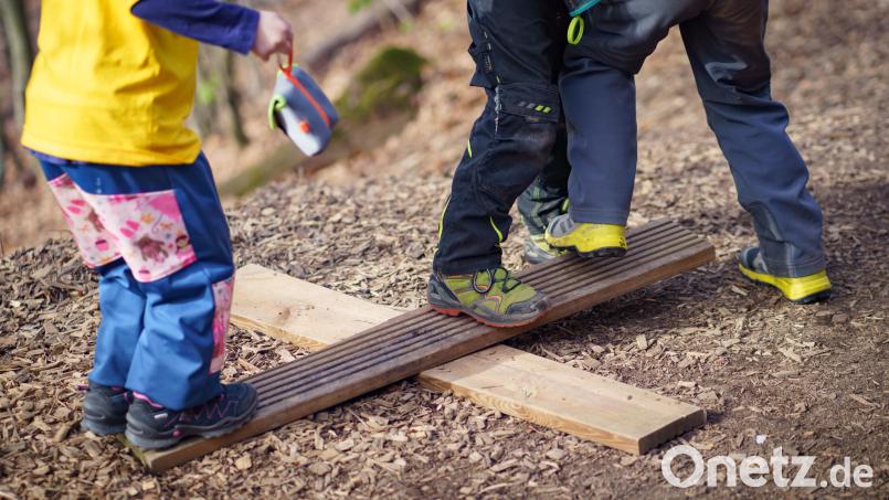 So einfach kann es sein: Aus zwei Brettern machen sich Kinder im Waldkindergarten fix eine kleine Wippe. Symbolbild: Frank Rumpenhorst/dpa