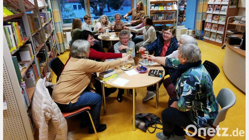 Das Büchereiteam in Eslarn um Melanie Frank (stehend hinten) versorgt die Lesebegeisterten mit Sekt und Snacks. Bild: gz