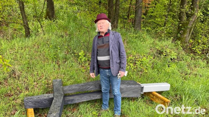 Holzbildhauer Michael Lauss mit dem Kreuz, das er für den Etsdorfer Kreuzeweg entworfen und umgesetzt hat. Bild: gri