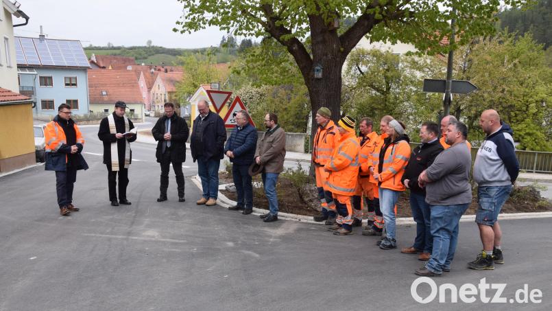 Früher als geplant ist der Ausbau der Engstelle der Staatsstraße 2235 im Ortsbereich von Hohenburg abgeschlossen (von links: Baudirektor Stefan Noll, Pfarrer Hans Zeitler und Bürgermeister Florian Junkes zusammen mit den Mitarbeitern des Bauhofes und den Vertretern der Firma Strabag. Bild: bö