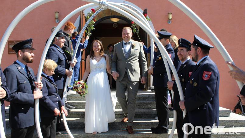 Nach dem Jawort in der Christuskirche in Schwend schreiten Christina und Max Herbst durch das Schlauchspalier der Feuerwehr Poppberg. Bild: sis