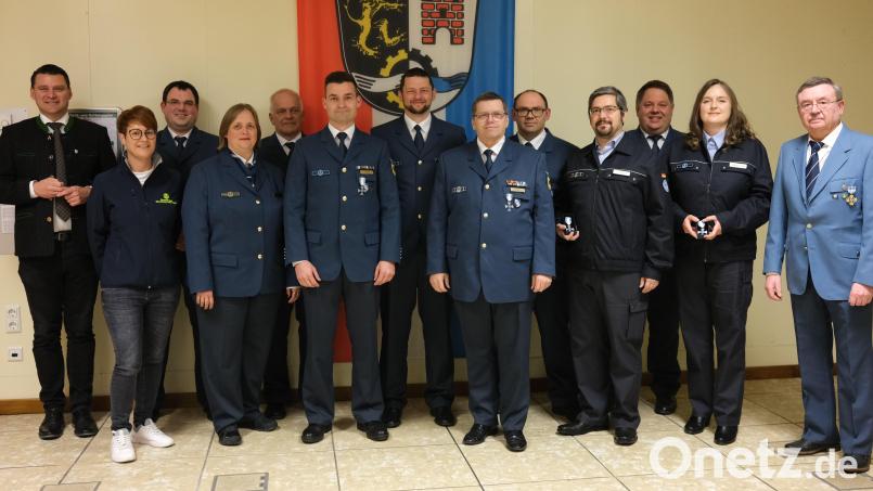 Landrat Thomas Ebeling (links) überreicht langjährigen Kameraden des Technischen Hilfswerkes das staatliche Ehrenzeichen. Seit 50 Jahren ist Ernst Pirzer (rechts) beim Ortsverband Schwandorf aktiv. Bild: Hirsch
