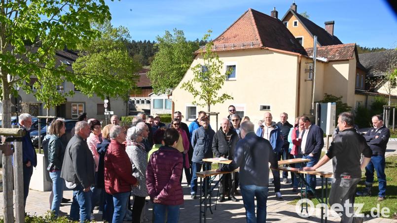 Rund 50 Poppenrichter Bürger informieren sich über die künftige Nutzung des alten Mesnerhauses (im Hintergrund) und bringen eigene Anregungen und Wünsche ein. Bürgermeister Hermann Böhm und Klaus Zeitler (beide mit dem Rücken zur Kamera) moderierten den Bürgerdialog. Bild: gf