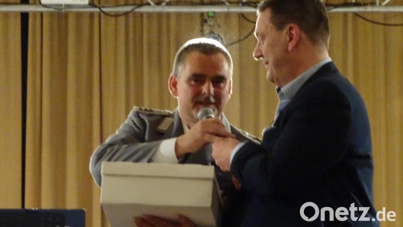 Der aus Maxhütte-Haidhof stammende Alexander Schöffel (links) spielt in Schwarzenfeld sein letztes Hallenkonzert mit dem Gebirgsmusikkorps der Bundeswehr. Sein Freund und früherer Berufskollege Christian Ziegler
(rechts) schenkt ihm einen Karton. Darin befindet sich eine Torte, der man in der Konditorei die Form einer Trommel gegeben hatte. Bild: Houschka