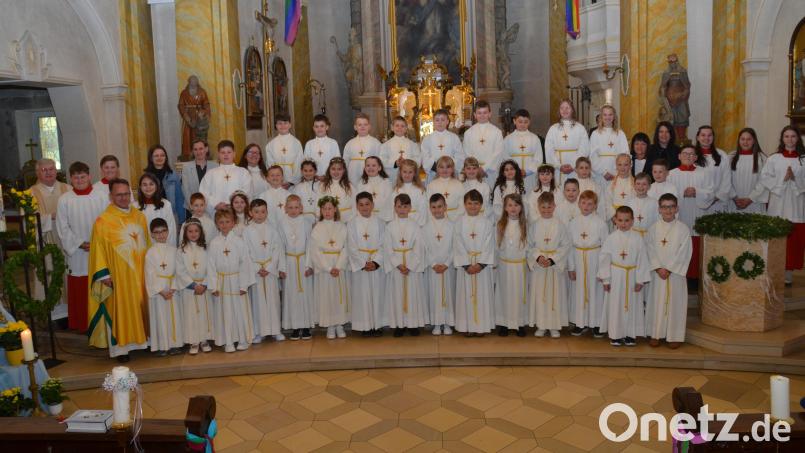 Die 41 Buben und Mädchen verbanden sich an ihrer Erstkommunion symbolisch unter dem Regenbogen mit Gott. Dekan Alexander Hösl (links) feierte einen denkwürdigen Tag mit den Kindern und deren Familien. Bild: dob
