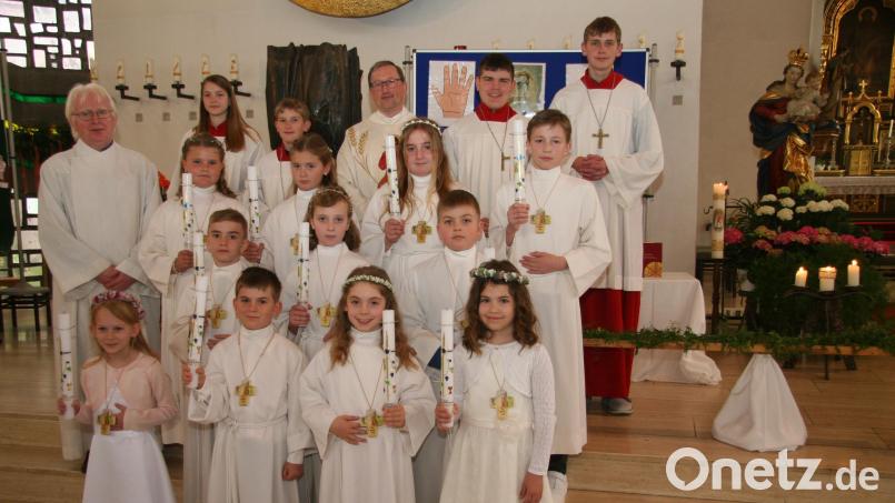 Elf Kinder empfingen in der Pfarrkirche in Gebenbach zum ersten Mal die Kommunion aus der Hand von Pfarrvikar Christian Preitschaft (hinten Mitte). Angeleitet wurden sie dabei von Wolfgang Schöpf (links). Bild: swo