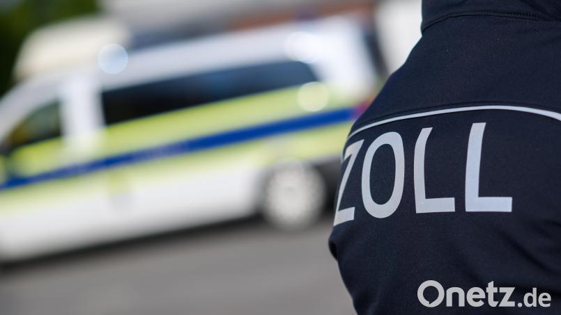 Ein Zollbeamter steht vor einem Dienstfahrzeug. In Weiden kontrollierten am Dienstag 20 Zöllner zwei Lokalitäten in der Innenstadt. Dem ehemaligen Geschäftsführer wird Sozialversicherungsbetrug vorgeworfen. Symbolbild: Julian Stratenschulte /dpa