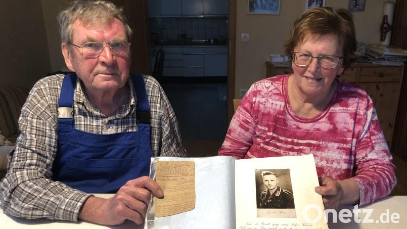 Margarete und Johann Farchmin halten mit dem Buch und der Muttertagskarte, geschrieben von ihrem Vater und Schwiegervater Georg Kiendl, historische Dokumente in ihren Händen. Bild: mis
