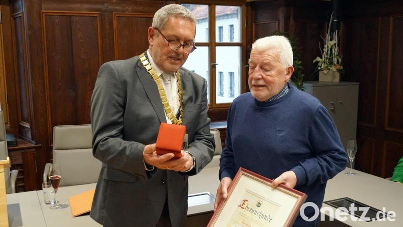 Bürgermeister Joachim Neuß (links) übergibt Günter Himmelhuber die Bürgermedaille und die Ehrenurkunde. Bild: jma