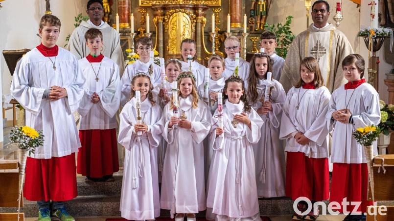 Pfarrer John Subash Vincent (hinten, rechts) und Pfarrvikar Amaidhi Arasu Kulandaisamy (hinten, links) freuen sich mit den Erstkommunikanten. Bild: Pilfusek/exb
