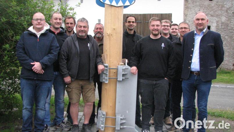 Stolz sind Rainer Stengel (Vierter von links) und Max Scholz (Fünfter von rechts) mit ihrer Mannschaft auf die neue Maibaumhalterung. Bild: knh
