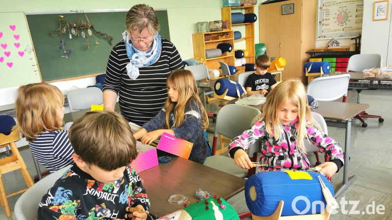 Klöppeln steht an der Grundschule Schönsee jeden Montag im Stundenplan. Ludwig und Steffi (vorne) arbeiten am Klöppelsack, während Frieda Roith bei der Suche nach einem neuen Motiv beratend unterstützt. Bild: Portner