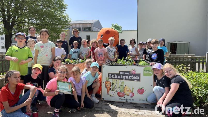 Stolz zeigen die erfolgreichen kleinen Gärtnerinnen und Gärtner ihre soeben selbst aufgebauten und bepflanzten Hochbeete. Bild: Baywa-Stiftung/exb