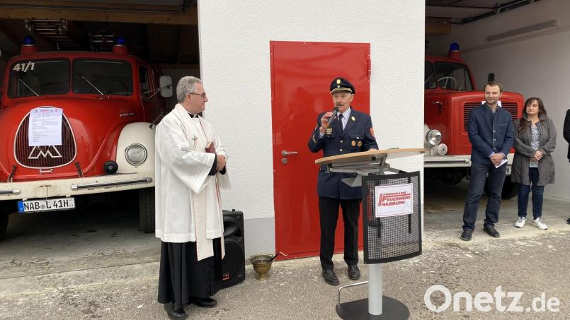 Vorstand Johann Gietl (Mitte) konnte Einiges zu den beiden Oldtimer-LKW und zum Bau der neuen Unterstellhalle, die Pfarrer Hannes Lorenz (links) segnete, berichten. Bild: Raphael Haubelt/exb