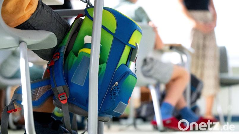 Ein Rucksack hängt im Klassenzimmer am Tisch eines Grundschülers. Bild: Sven Hoppe/dpa/Symbolbild