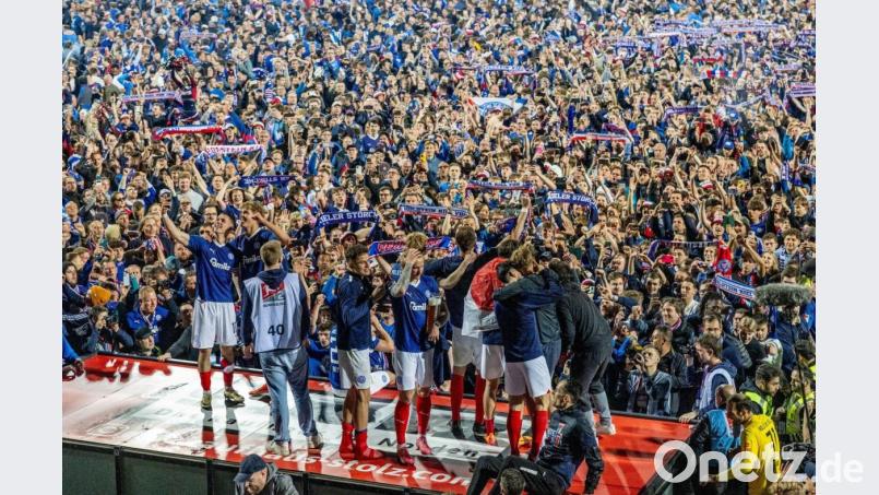 Die Kieler Spieler feierten mit den Anhängern, die nach dem Schlusspfiff auf das Spielfeld gestürmt waren. Bild: Axel Heimken/dpa