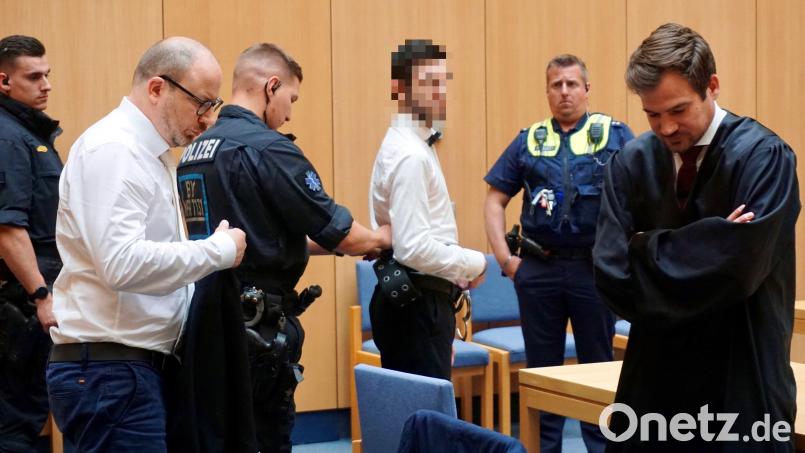 Ein Polizist legt dem Angeklagten seine Handfesseln wieder an. Im Vordergrund die beiden Verteidiger des 29-jährigen Drogendealers, Dominic Kriegel (vorne links) aus Weiden und Johannes Büttner aus Regensburg. Bild: jut