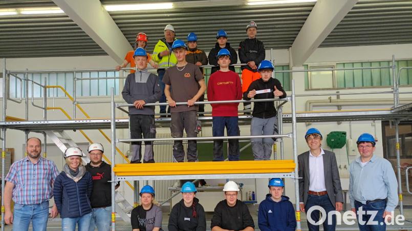 Schülerinnen und Schüler aus der Abteilung Bauwesen freuen sich mit Fachlehrer Michael Kleber und Schulleiter Thomas Metzler (von rechts), Abteilungsleiter Jürgen Böckl (links) sowie Vertretern der Gerüstbaufirma darüber, dass der Unterricht auf dem neuesten Stand gehalten werden kann. Bild: Julius Neugebauer/exb