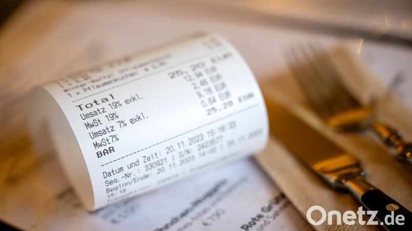 Eine Rechnung mit Umsatzsteuer und Mehrwertsteuer liegt auf der Speisekarte eines Restaurants. Steuer-Kritik kam auch zur Sprache bei der Wirtshausdebatte mit Finanzstaatssekretär Martin Schöffel in Amberg. Symbolbild: Sina Schuldt/dpa