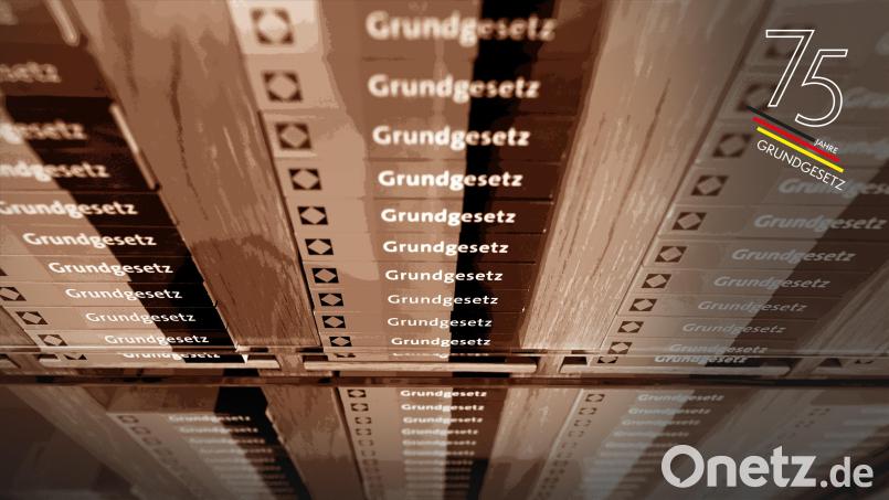 Im Foyer des Bundesverfassungsgerichts liegen in einem Schrank Miniaturausgaben des Grundgesetzes. Symbolbild: Uli Deck/dpa; Bildmontage: Laura Fröhler