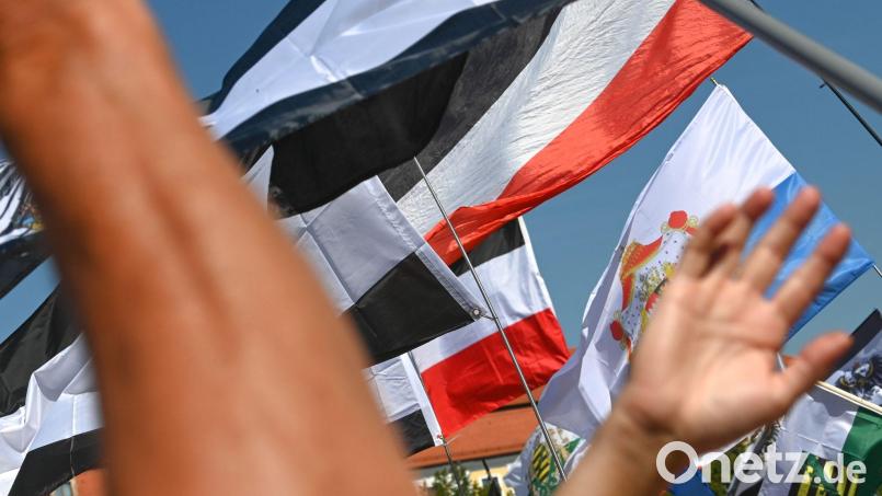 Reichsflaggen werden auf dem Magdeburger Domplatz zur Reichsbürgerkundgebung hochgehalten. Bild: Heiko Rebsch/dpa/Illustration