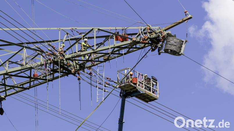 Arbeit in luftiger Höhe: An einem Mast des Ostbayernrings bei Irrenlohe werden die Leiterseile gezogen. Von der Traverse und der Plattform eines Hubsteigers aus wird in etwa 30 Metern Höhe gearbeitet. Bild: Hösamer
