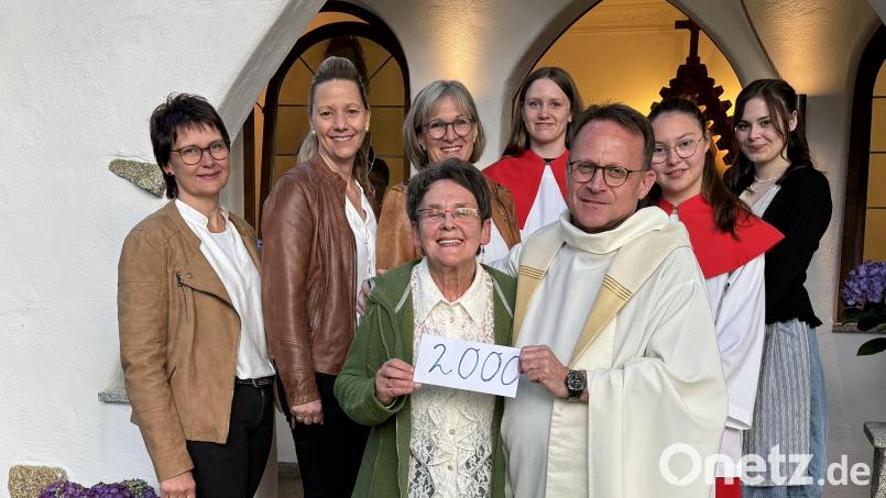 Christa Wildenauer übergibt im Beisein der Waldthurner Gesangsgruppe &quot;TriAngel&quot; und Vohenstraußer Ministranten 2000 Euro an Pfarrer Alexander Hösl. Bild: H. Wildenauer/exb