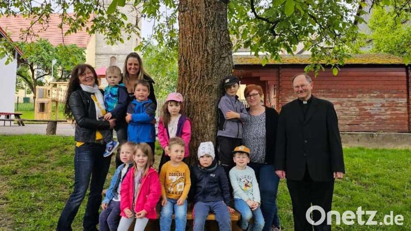 Lisa Schiml (von links) und Stefanie Schrembs (Vorsitzende des Frauenbund Waldeck) an der neuen Bank mit (von rechts) Pfarrer Heribert Stretz und Kindergartenleiterin Kerstin Dilling im Kreise von zahlreichen Kindern. Bild: Frauenbund Waldeck/exb