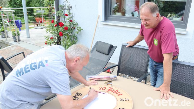 Malermeister Johann Frind (links) fertigt die Festscheibe, die am Sonntag, 16. Juni, vergeben wird. Erster Schützenmeister Heiner Graf ist auf das Motiv gespannt, das Schirmherr Hans Ram als Stifter der Scheibe festgelegt hat. Bild: mrr