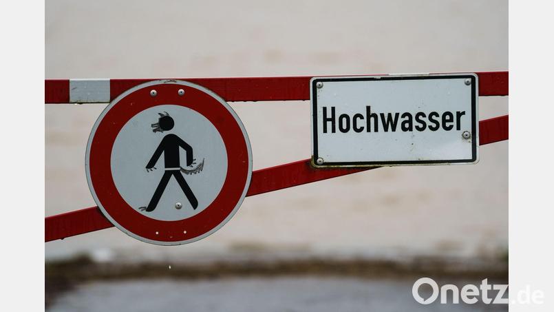 Ein Hochwasser-Schild steht an einem überfluteten Feld. Bild: Andreas Arnold/dpa/Symbolbild