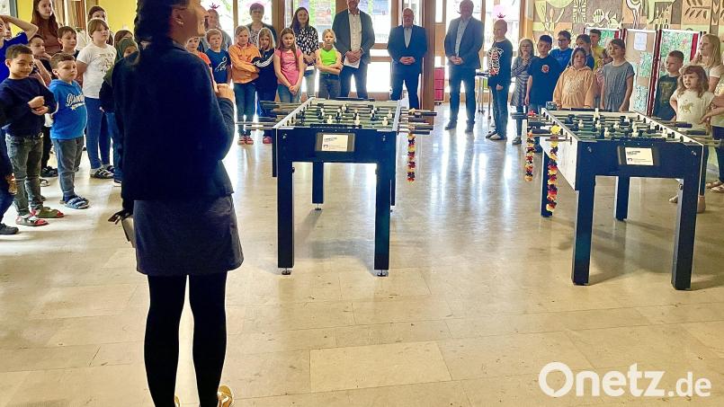 Rektorin Julia Stiegler und die Kinder der Josef-Voit-Grundschule mit den Gästen und ihren neuen Kickern bei der Spendenübergabe. Bild: Krones