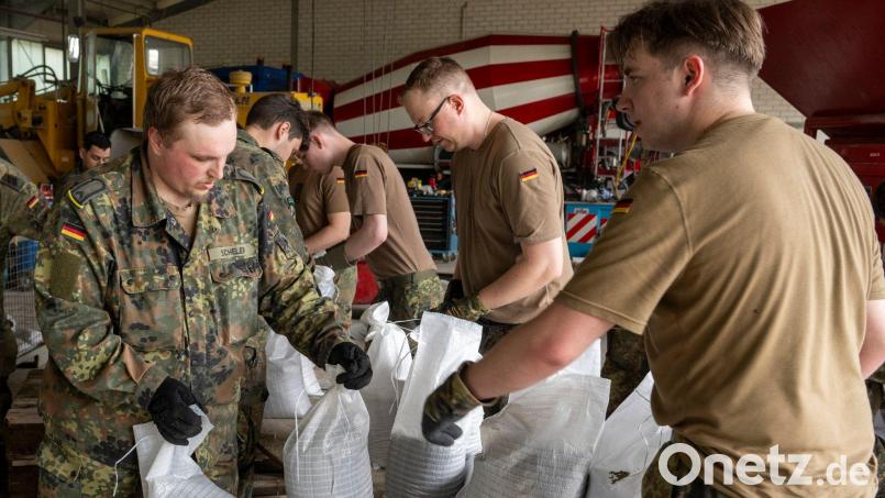 In einem Betonwerk füllen Soldaten der Bundeswehr Sandsäcke ab. Bild: Stefan Puchner/dpa
