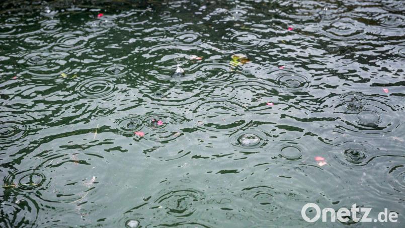 Regen tropft in einen Brunnen. Bild: Daniel Vogl/dpa/Symbolbild