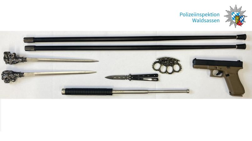 Das Bild zeigt einen Teil der sichergestellten Waffen, u.a. die zwei Gehstöcke mit der doppelseitig geschliffenen Klinge. Bild: Polizeiinspektion Waldsassen/exb