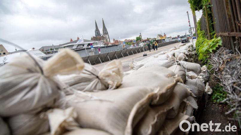 Ein Uferweg in Regensburg ist mit einer mobilen Hochwasser-Schutzwand gesichert, Sandsäcke liegen bereit. Die Donau ist bereits weit über die Ufer getreten. Das Hochwasser soll weiter steigen. Bild: Pia Bayer/dpa