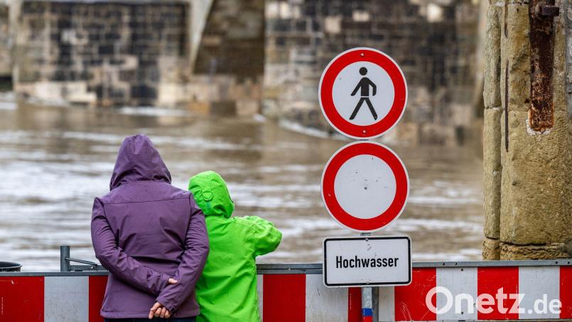 Ein Schild warnt an der Steinernen Brücke vor dem Hochwasser der Donau. In Regensburg wurde am Montag der Katastrophenfall ausgerufen. Symbolbild: Armin Weigel/dpa