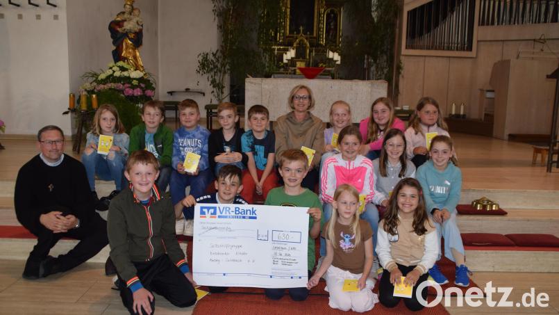 Nach der Schülermesse überreichen die Kommunionkinder aus den Pfarreien Ursulapoppenricht und Gebenbach zusammen mit Pfarrvikar Christian Preitschaft (links) eine Spende von 630 Euro an Petra Waldhauser (Mitte) von der Selbsthilfegruppe krebskranker Kinder Amberg-Sulzbach. Bild: swo