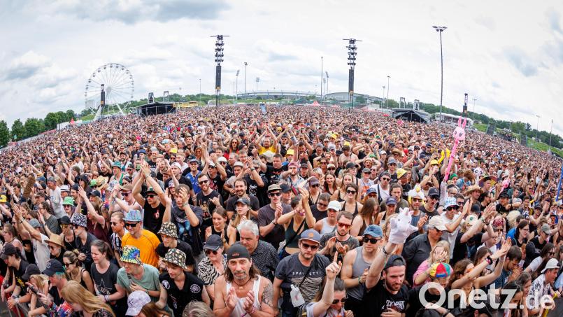 Das Publikum feiert auf Rock in Park. Im Hintergrund ist das Riesenrad zu sehen. Dort sollen Männer rassistische Parolen gerufen haben. Bild: Daniel Karmann/dpa