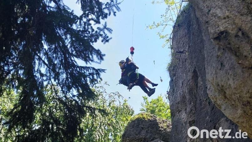 Der Luftretter hat die Klettersteig-Geherin erreicht, Retter und Patientin werden am Windenseil vom Felsen geflogen. Bild: Alexander Renner, Bergwacht Amberg/exb