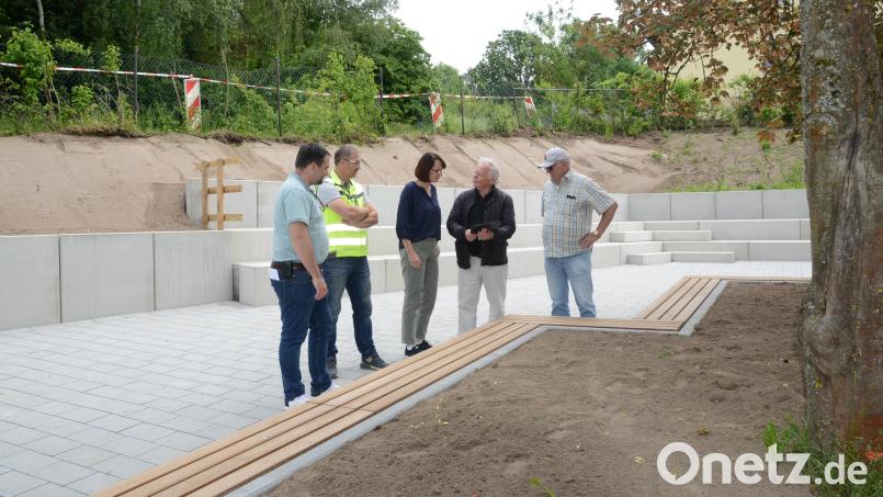 Ein Blick auf den umgestalteten Pausenhof der Grundschule Luhe-Wildenau. Bürgermeister Sebastian Hartl (links) Schulleiterin Sandra Landgraf (Mitte) und Architekt Josef Schöberl (Zweiter von rechts) sehen sich noch einmal um, bevor die Kinder das Areal in Beschlags nehmen. Im Hintergrund sichtbar die zweistufige Böschungssicherung. Bild: bey